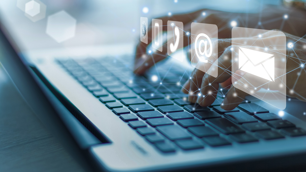 Hands typing on a laptop keyboard with overlaid digital icons